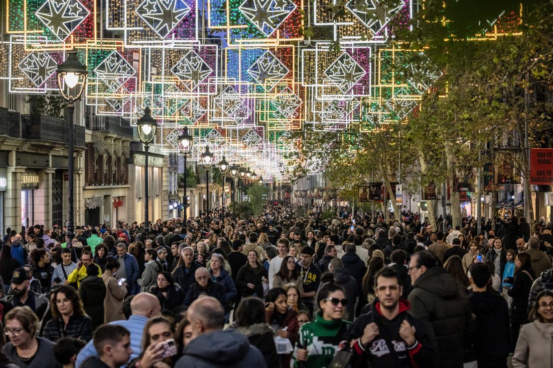 Crowds walk under festive decorations on the Portal de l'Angel pedestrianized retail street in Barcelona, Spain, on Saturday, Dec. 9, 2023.