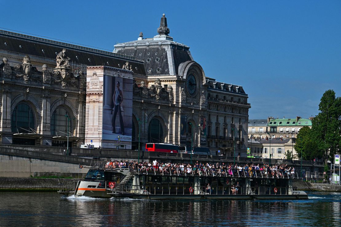 Tourists visit Paris aboard an open excursion boat (Bateaux mouches) on the Seine river, with the Musee d'Orsay seen in the background, in Paris on August 22, 2023. (Photo by MIGUEL MEDINA / AFP) (Photo by MIGUEL MEDINA/AFP via Getty Images)