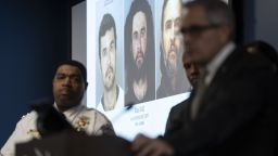 Images of suspect Elias Diaz are projected on a screen between Interim Police Commissioner John Stanford, Jr., left, and District Attorney Larry, right, during a news conference in Philadelphia, Tuesday, Dec. 19, 2023. Authorities say Diaz, accused of slashing people with a large knife while riding a bicycle on a rail trail in Philadelphia is now a person of interest in the cold-case murder of a medical student that occurred among a series of high-profile sexual assaults two decades ago. (AP Photo/Matt Rourke)