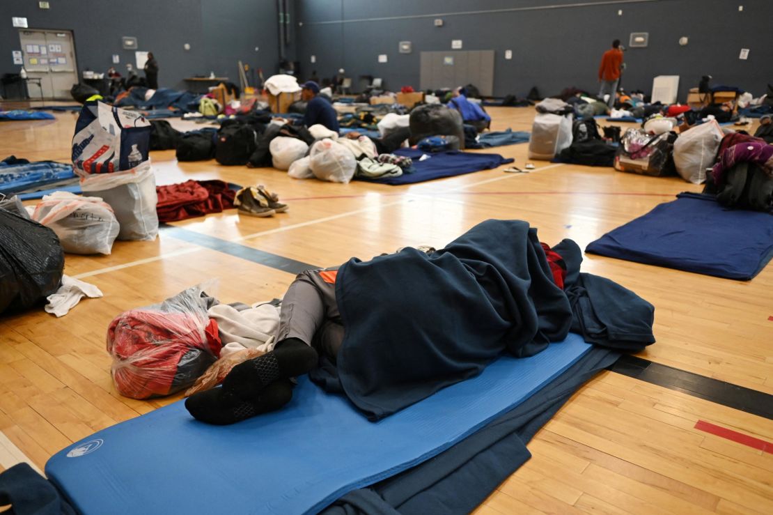 DENVER, CO - JANUARY 13 : A migrant lies on the sleeping pad at a makeshift shelter in Denver, Colo., on Friday, Jan. 13, 2023.  Hyoung Chang/Pool via REUTERS