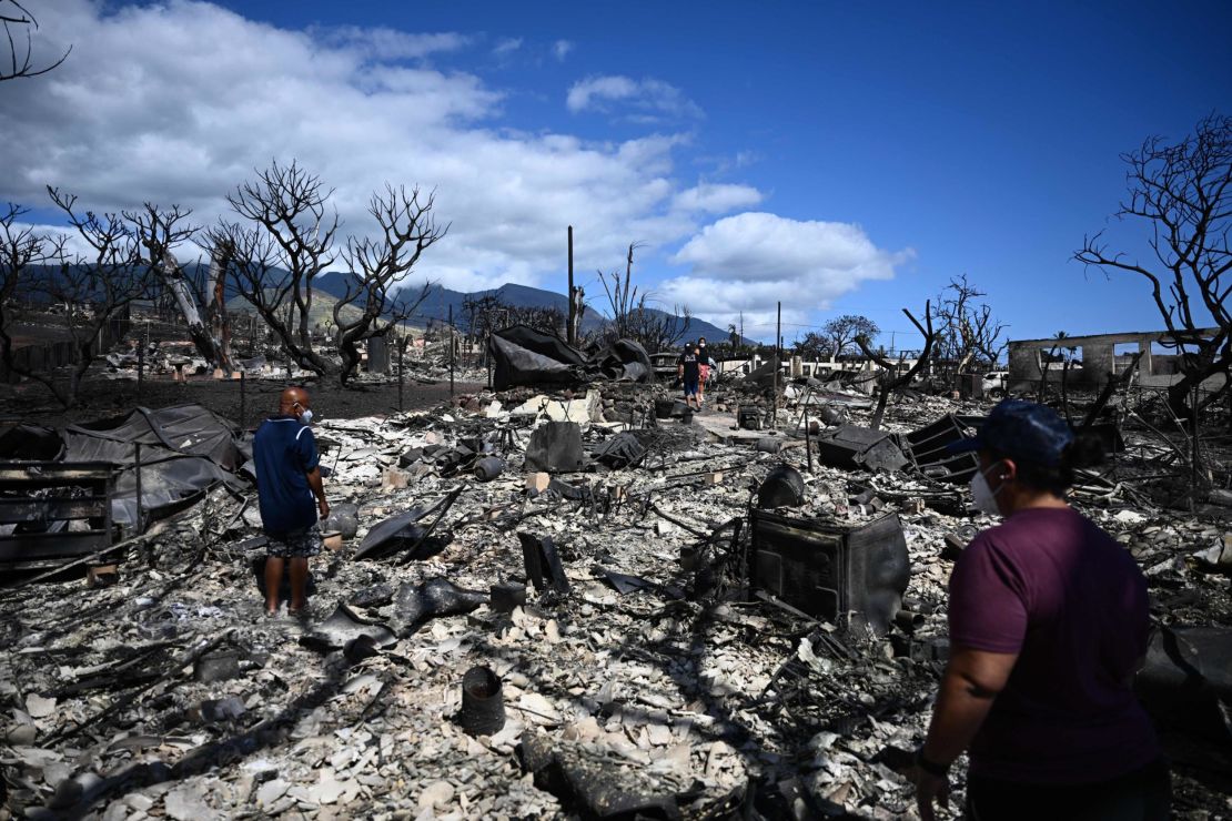 The Ganer family look through the ashes of their family's home on Malolo Place in the aftermath of a wildfire in Lahaina, western Maui, Hawaii on August 11, 2023.