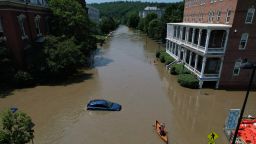 A person paddles a canoe down a street flooded by recent rain storms in Montpelier, Vermont, U.S., July 11, 2023.
