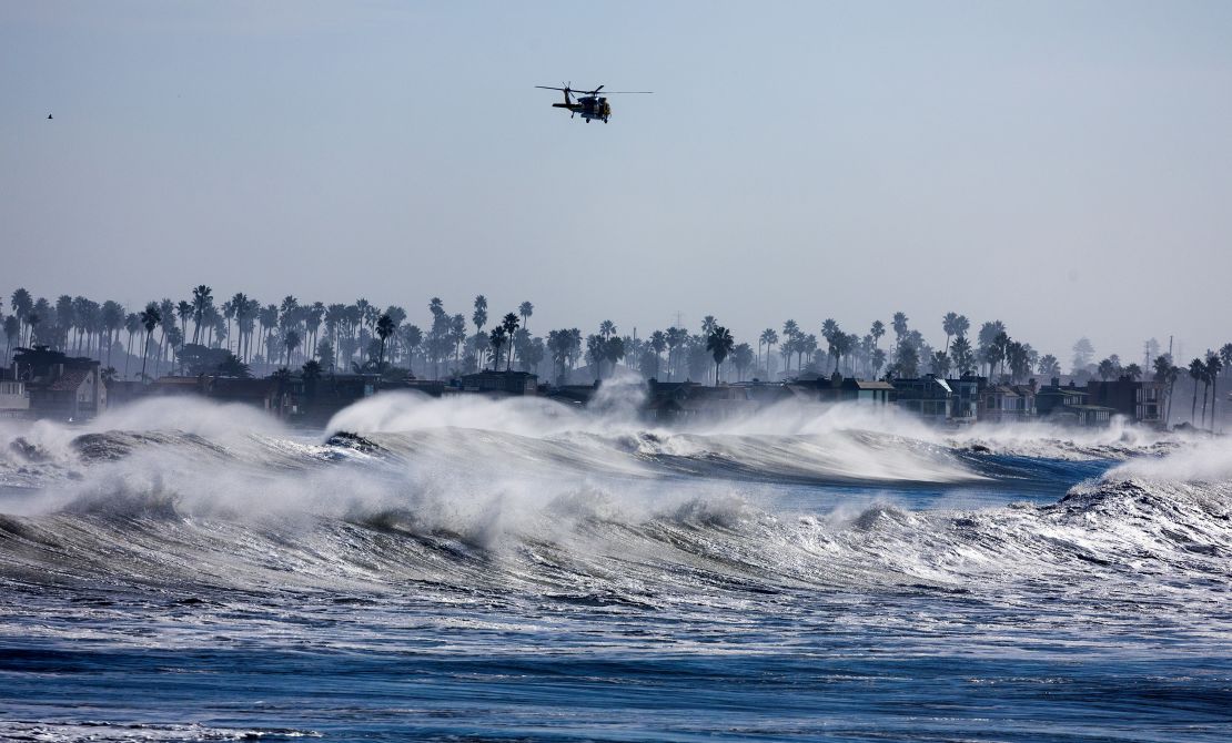 Ventura, CA - December 28: Ventura County fire helicopter patrols the coastline over heavy surf south of Ventura Pier on Thursday, Dec. 28, 2023 in Ventura, CA. Most of the pier was closed due to the surf. (Brian van der Brug / Los Angeles Times via Getty Images)