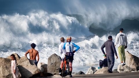 Beachgoers watch as huge surf pounds the coast, in Manhattan Beach, Calif., Dec. 28, 2023. (AP Photo/Richard Vogel)