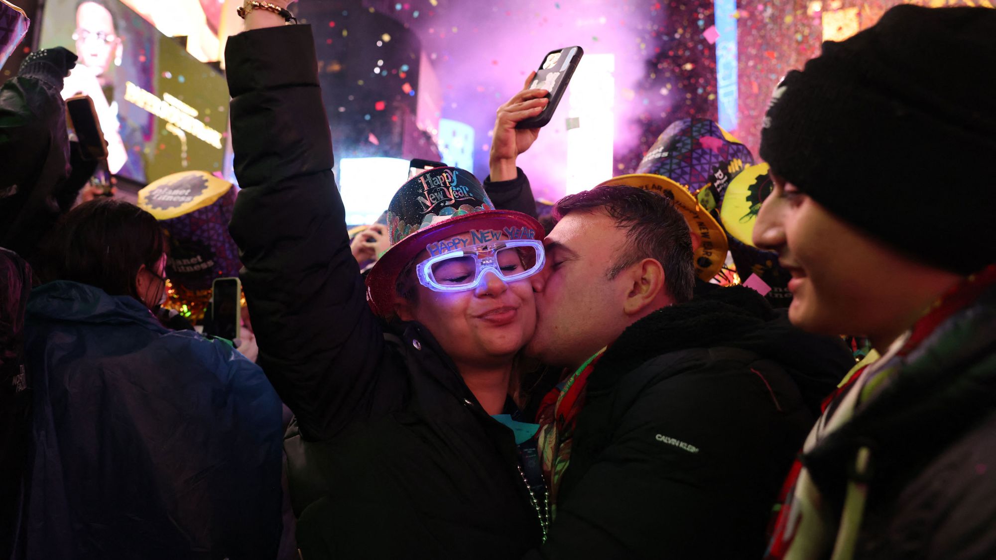 People kiss as confetti fills the air to mark the beginning of the new year, in Times Square, New York City, on January 1, 2023. (Photo by Yuki IWAMURA / AFP) (Photo by YUKI IWAMURA/AFP via Getty Images)
