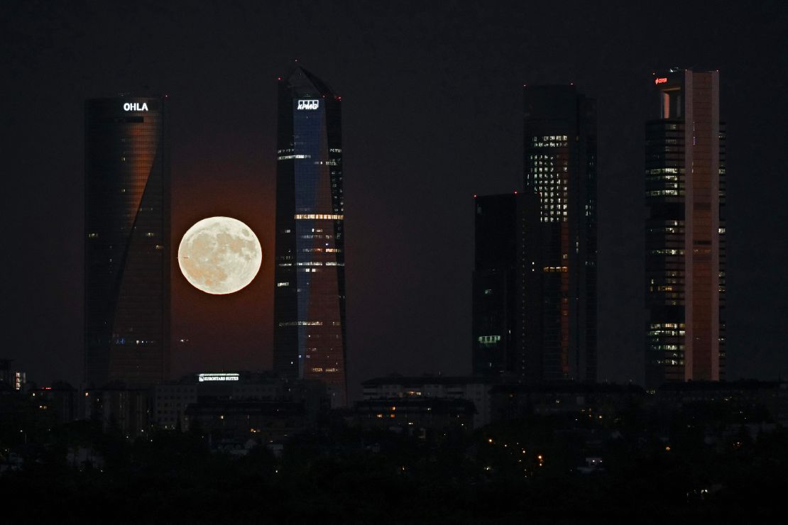 This picture taken on August 1, 2023 shows the second supermoon of 2023, also known as the Sturgeon Moon, rising behind the Cuatro Torres business area in Madrid. Algonquian native American tribes from the Great Lakes region in the United States named this full moon as 'Sturgeon Moon' because of the abundance of sturgeon fish in this period of the year. (Photo by JAVIER SORIANO / AFP) (Photo by JAVIER SORIANO/AFP via Getty Images)