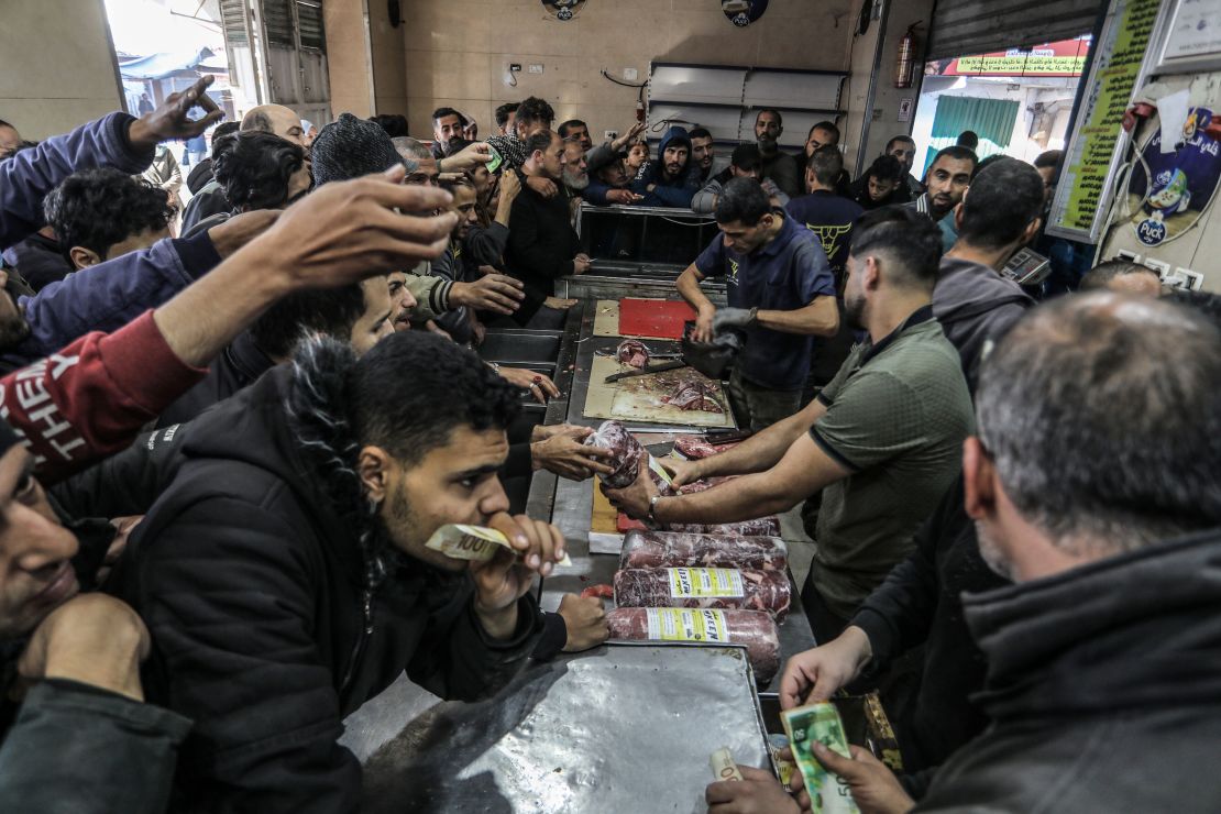 30 December 2023, Palestinian Territories, Rafah: Palestinians crowd to buy Egyptian frozen meat after the Israeli authorities allowed it to enter from the Karem Shalom crossing into the Gaza Strip. This is the first time frozen meat has entered since the war between Israel and the Hamas movement started.