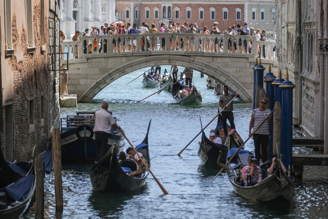 Gondoliers proceed slowly near the Sospiri Bridge near St. Mark's Square due to too much traffic on August 02, 2023 in Venice, Italy. UNESCO officials have included Venice and its lagoon to the list of world heritage in danger to review, along with Ukraine's Kyiv, and Lviv. The UN cultural agency deems Italy not effective in protecting Venice from mass tourism and extreme weather conditions.