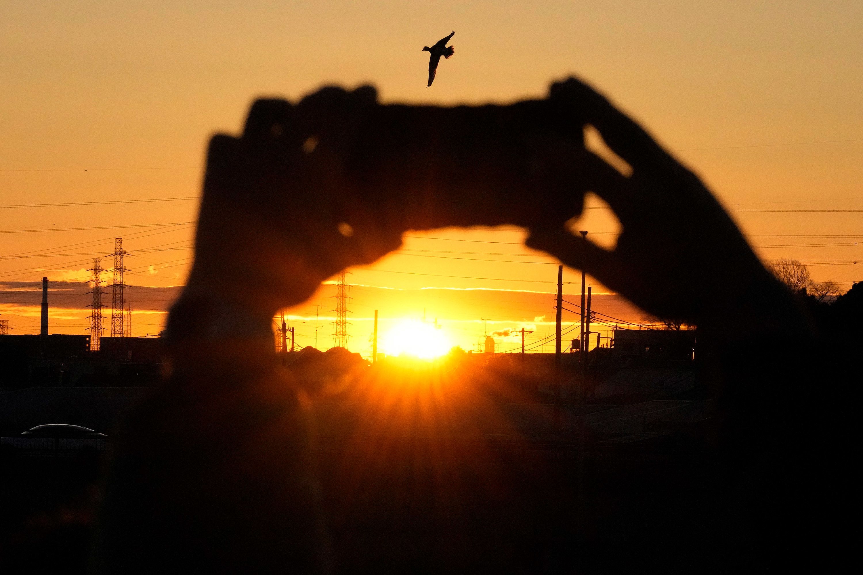 A person takes a photo of the first sunrise on New Year's Day in Yokohama, a Japanese city south of Tokyo.