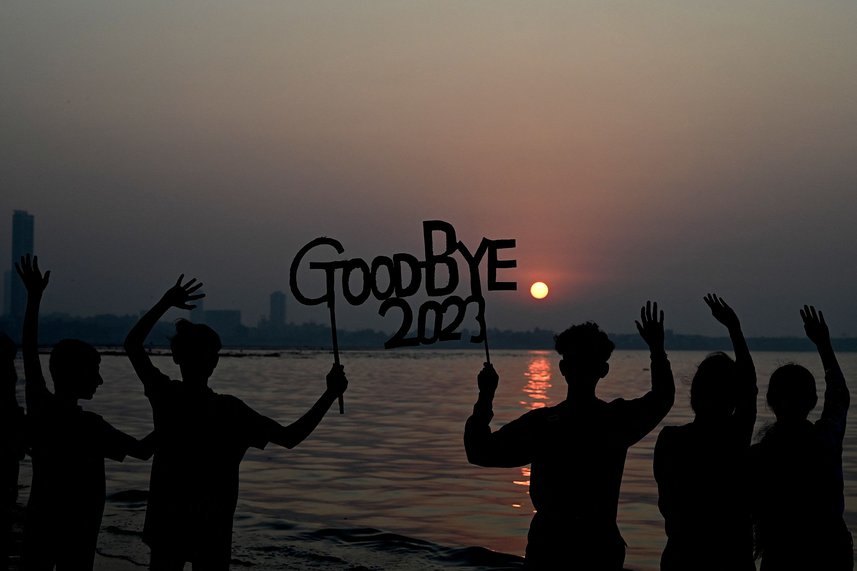 People gather along a beach in Mumbai, India, to bid adieu to the last sunset of the year.