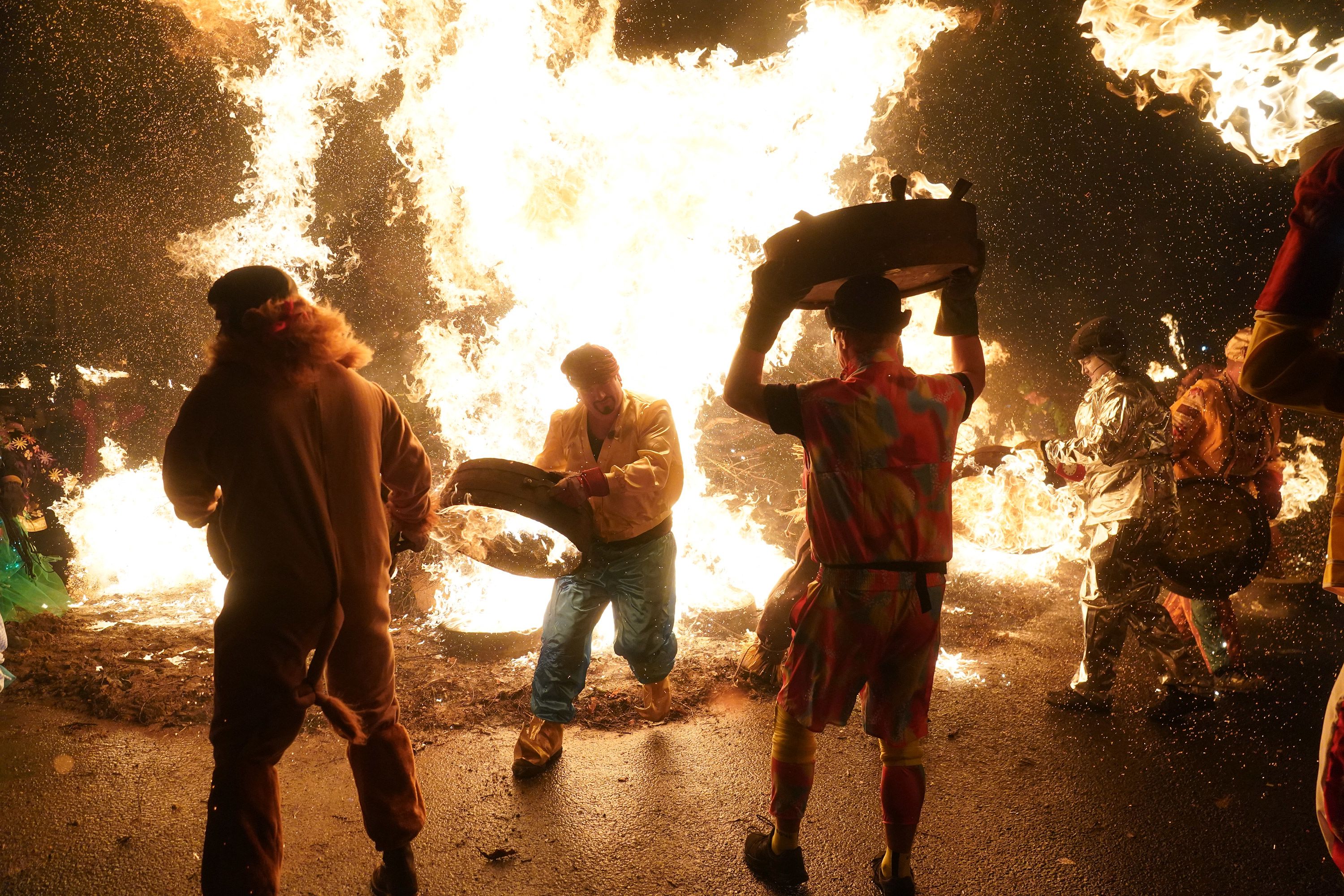 Men carry burning whisky barrels through the streets of Allendale, England, during the Tar Barrel festival.