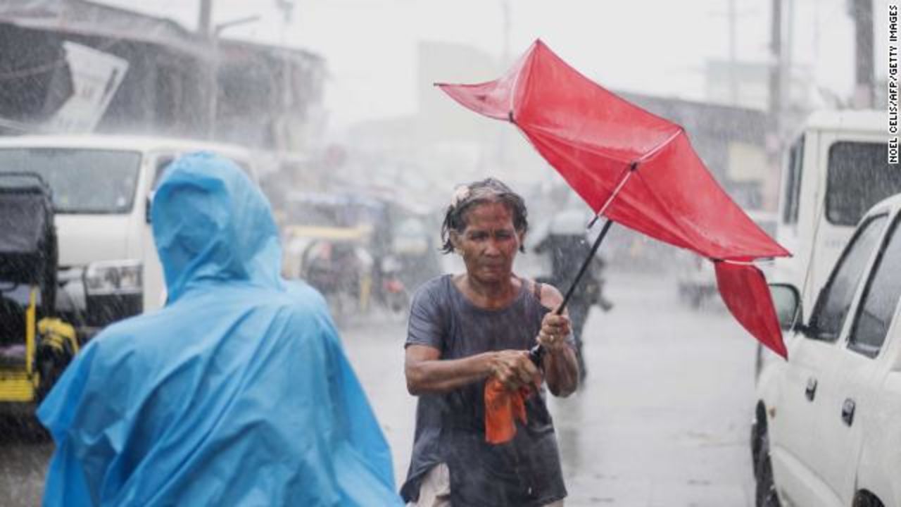 A woman holds her umbrella against the heavy rains pounding Manila on Saturday. 