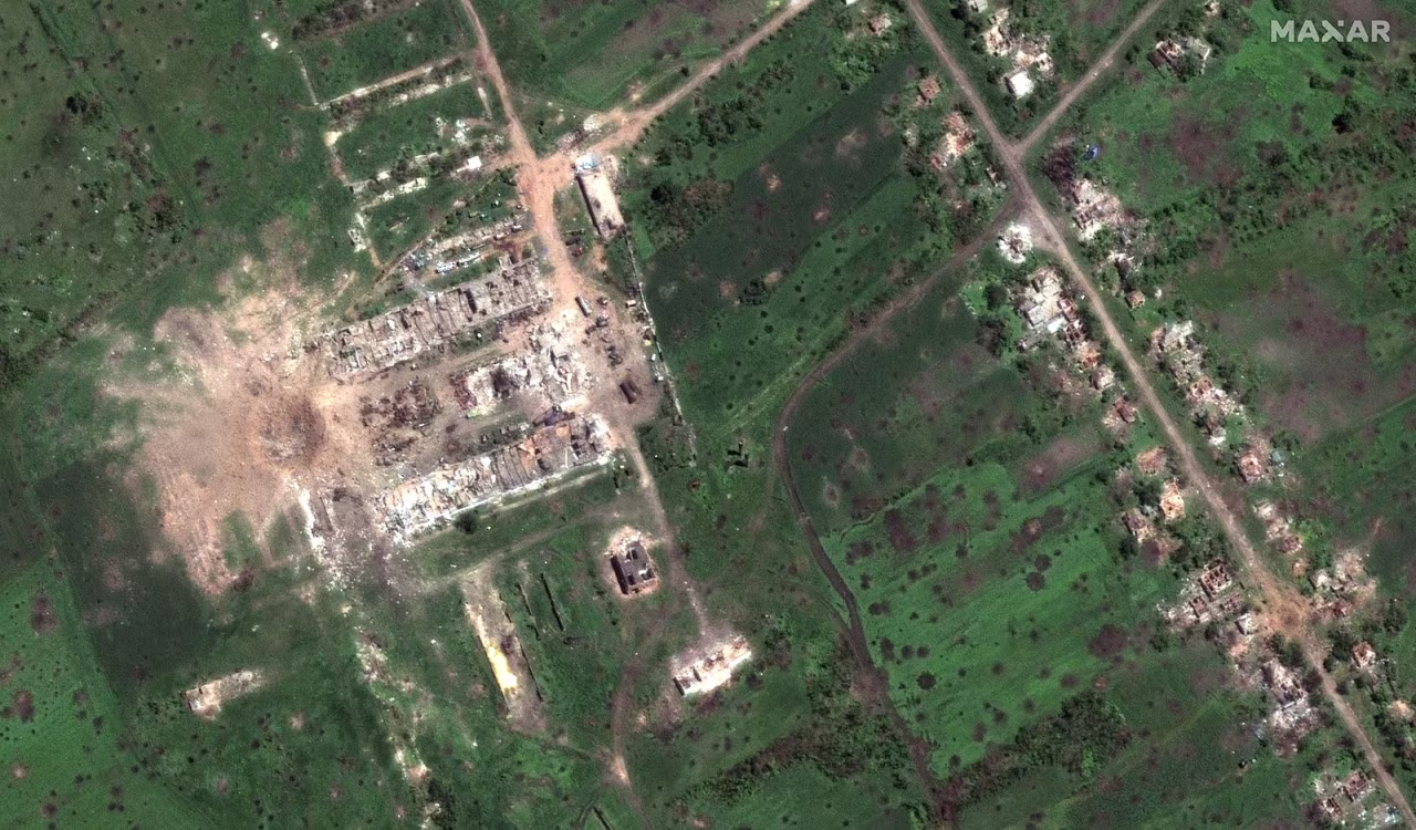 A large crater can be seen near what was a group of buildings outside the village of Dovhenke.