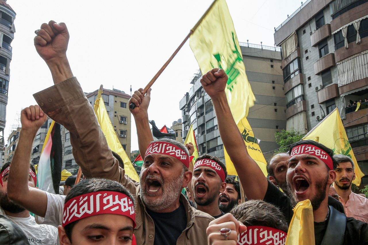 Protesters lift Hezbollah flags in front of the French embassy complex in Beirut on Wednesday.