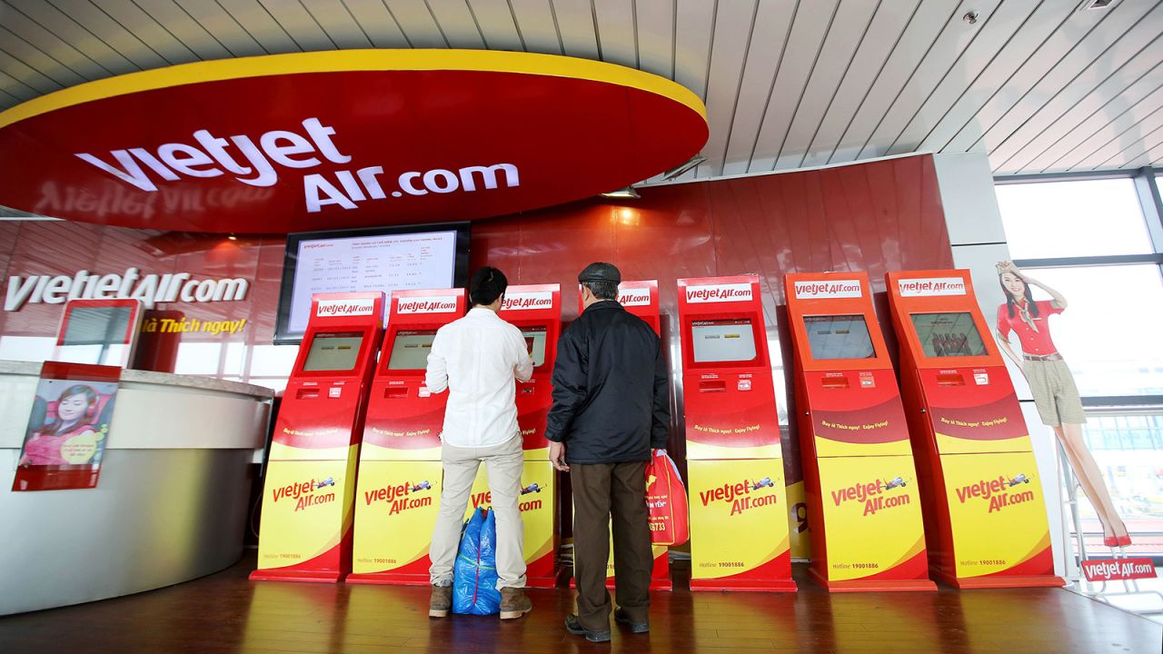 In this 2017 file photo, passengers use an automated check-in machine for VietJet Air at Noi Bai International Airport in Hanoi, Vietnam.