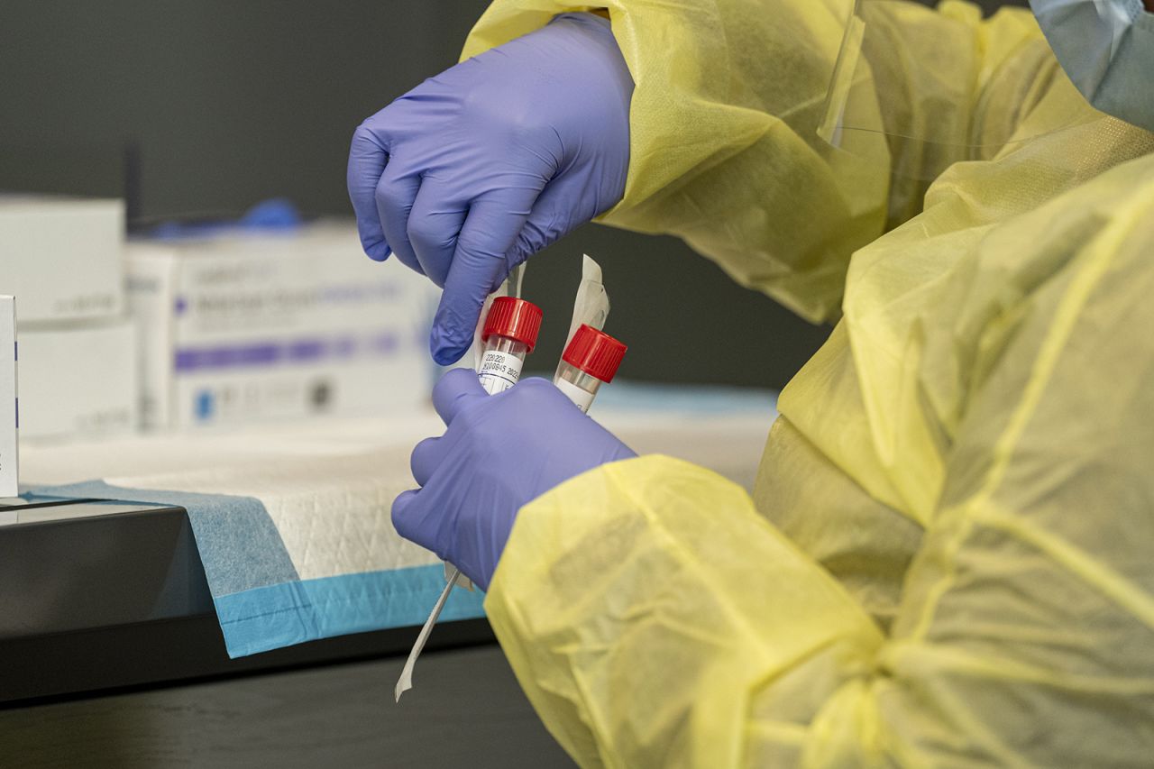 A medical worker seals a test tube with a Covid-19 nasal swab at San Francisco International Airport on Thursday, Dec. 2, 2021. 