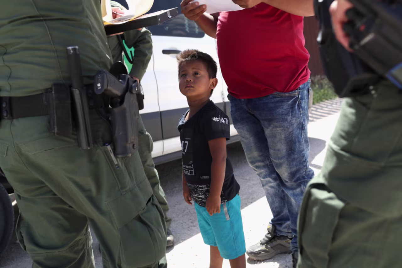 A boy and father from Honduras are taken into custody by U.S. Border Patrol agents near the U.S.-Mexico Border on June 12, 2018 near Mission, Texas.