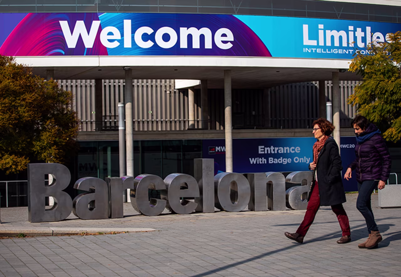People walk past posters announcing the Mobile World Congress 2020 in a conference venue in Barcelona, Spain, Tuesday, February 11.  The organizer of the event announced that it would be cancelled in a segment on Wednesday. 