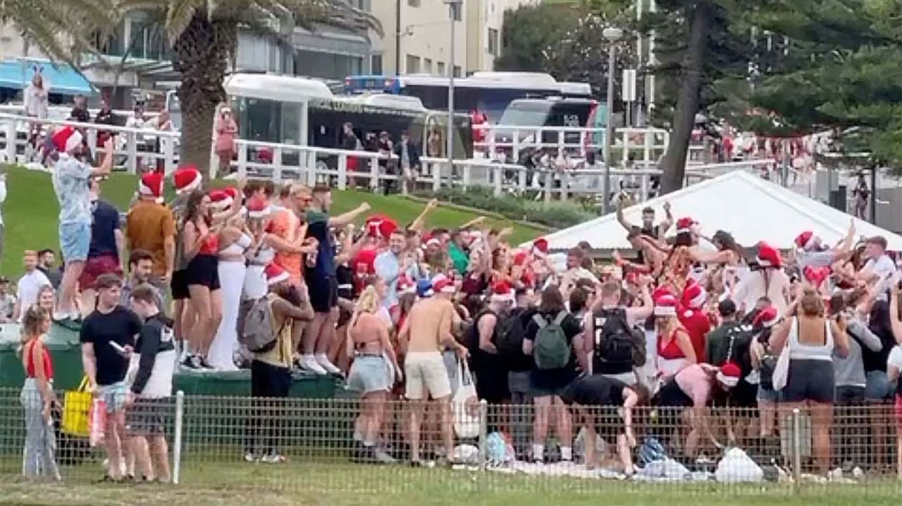 In this still image taken from a social media video, people wearing Santa hats gather at Bronte Beach, in Sydney, Australia, amid the coronavirus outbreak on December 25.