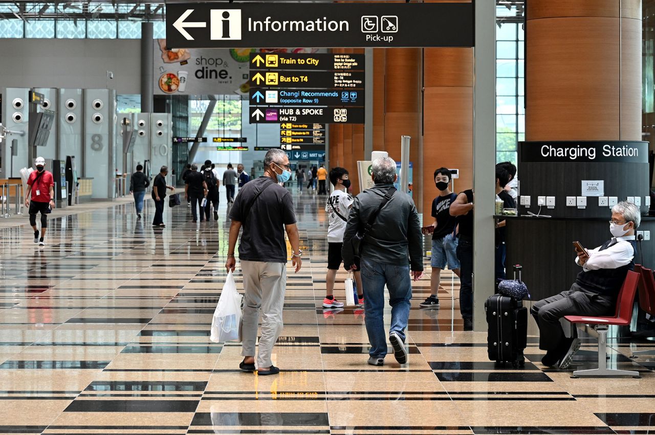 Travelers are seen in the departure hall of Changi International Airport in Singapore, on March 15.