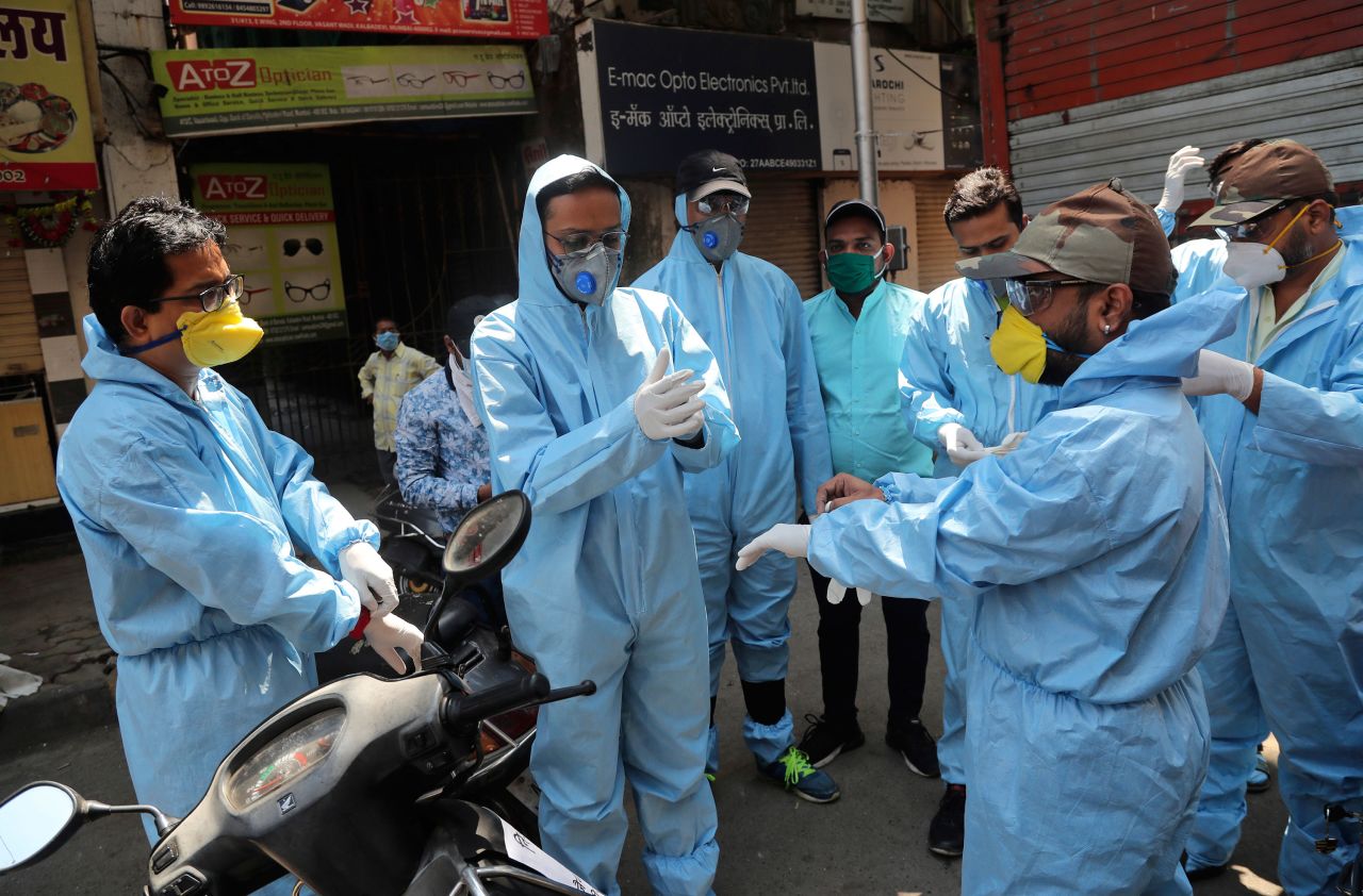 Members of a volunteer organization wear protective gear before distributing food to people in Mumbai, India, on March 29.