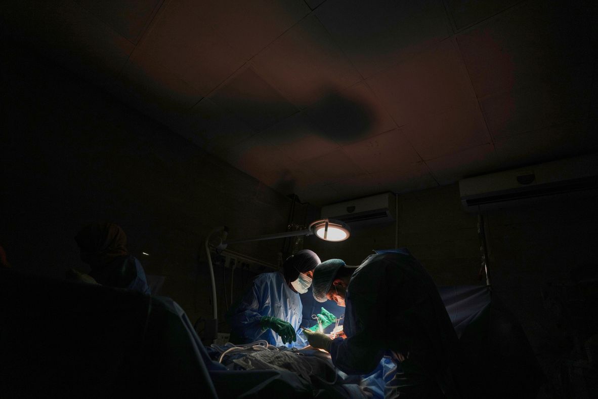 Dr. Abeer Al-Gharbawi, left, performs surgery under the illumination of a battery-powered light during a power outage at the Shifa Hospital in Gaza City on Friday, July 4. Hospitals in Gaza say that <a  target="_top" href="/newspapers?url=https://www.cnn.com/2025/07/09/middleeast/gaza-fuel-babies-incubator-intl">fuel shortages</a> are forcing them to shut off vital services, putting patients’ lives at risk.