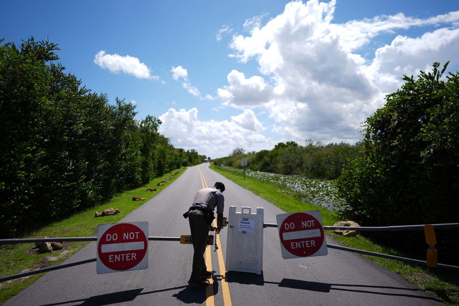 National Park Service ranger Greg Freeman opens a locked gate so he can enter the Shark Valley section of Florida's Everglades National Park on Wednesday, October 1, the first day of the government shutdown.