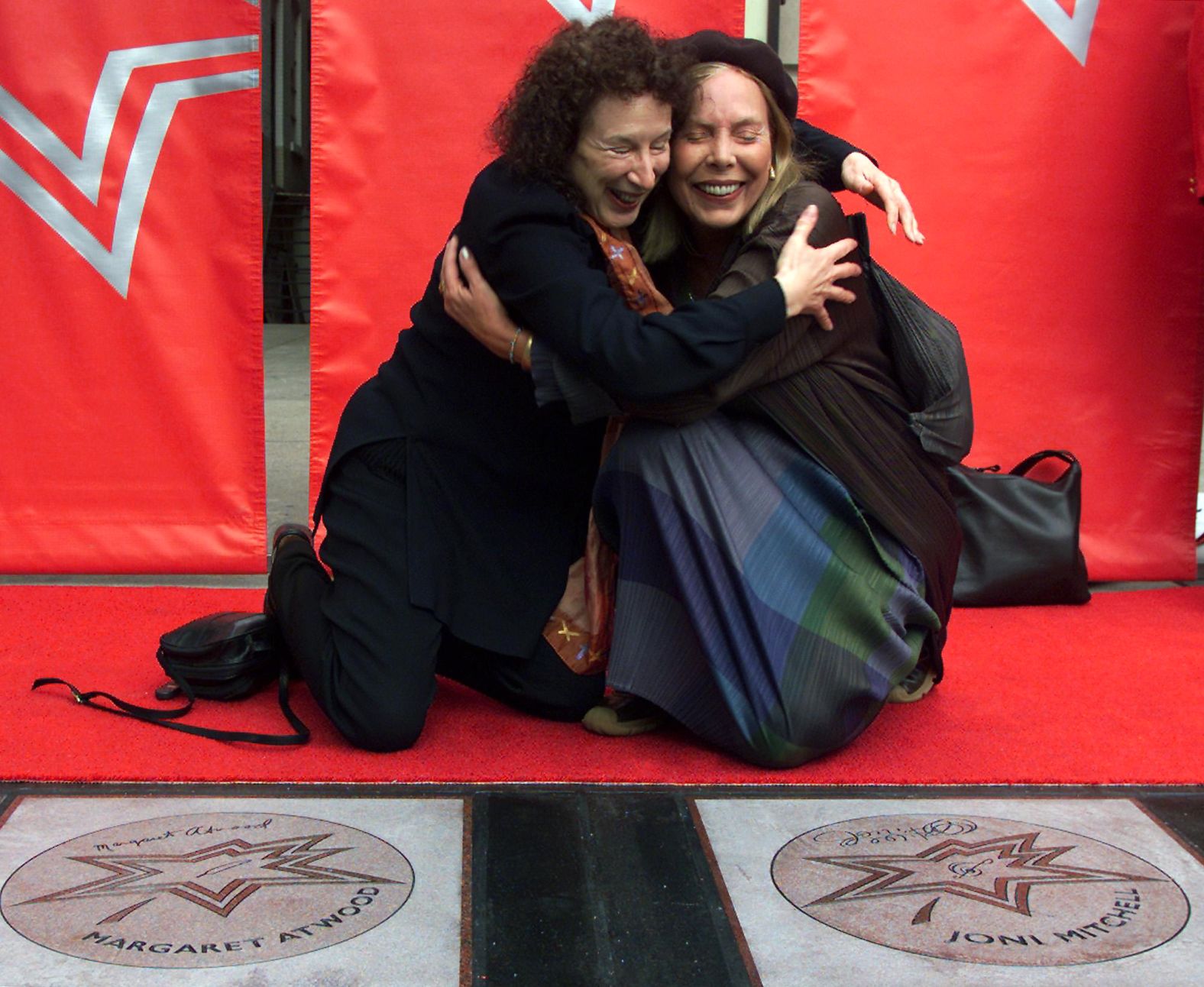 Author Margaret Atwood and Mitchell hug each other after unveiling their stars on the Canada Walk of Fame in 2001.