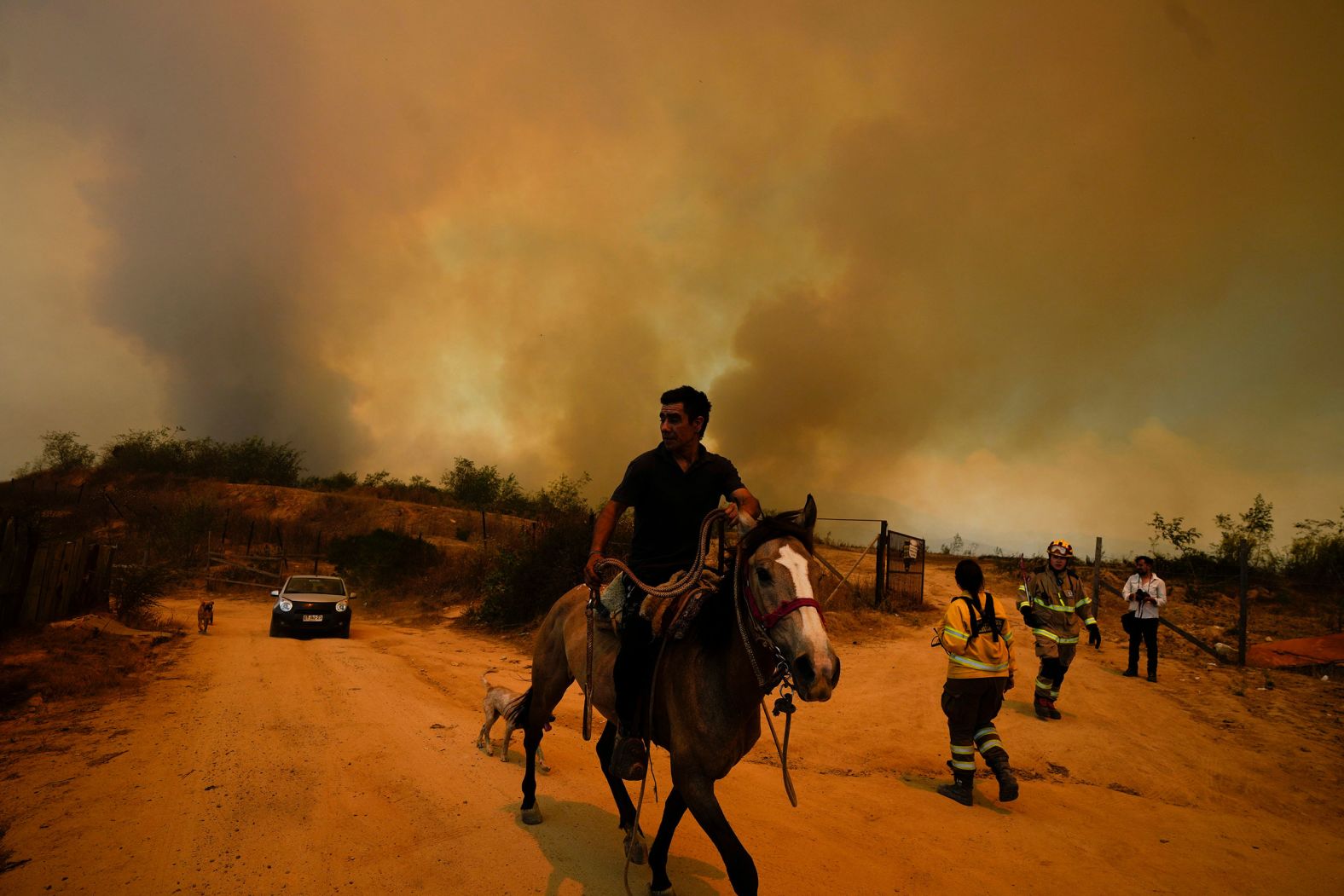 A resident flees an encroaching wildfire in Viña del Mar, Chile, on Saturday, February 3. <a href="index.php?page=&url=https%3A%2F%2Fwww.cnn.com%2F2024%2F02%2F06%2Fclimate%2Fchile-wildfires-deadliest-climate-intl%2Findex.html">The fires</a> in Chile have claimed more than 100 lives, and hundreds of people are still missing, according to Chilean authorities.