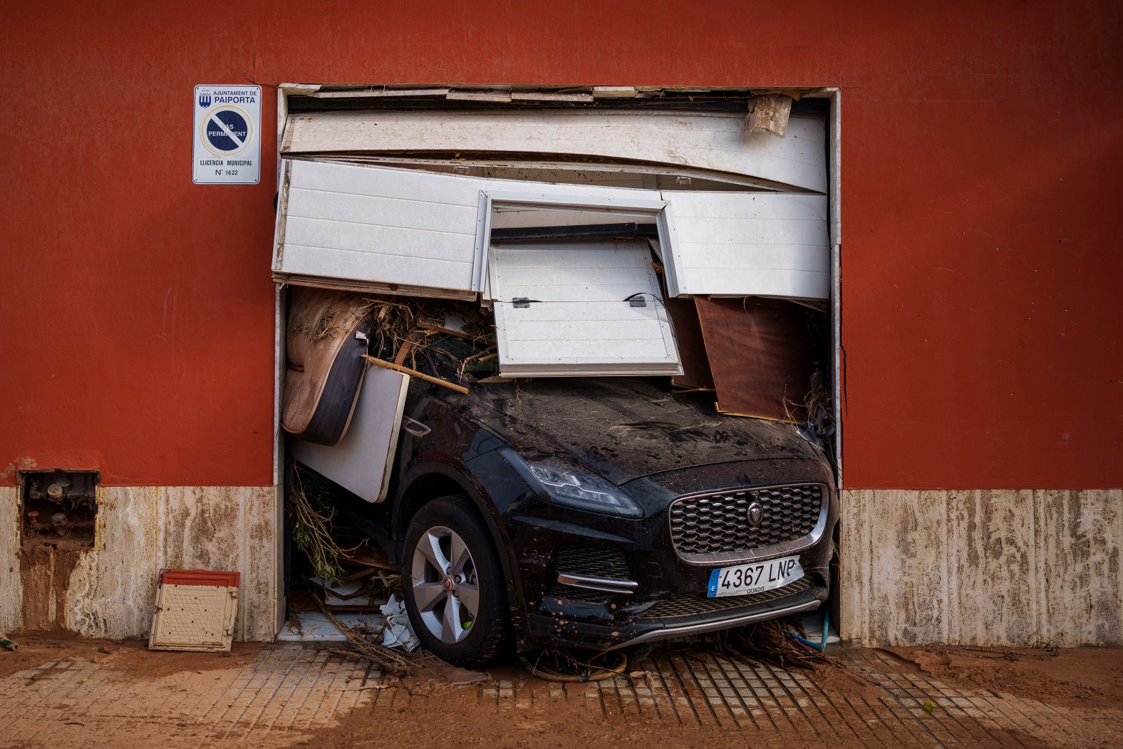 A car sticks out of a garage in Valencia, Spain, on Saturday, November 2. <a href="index.php?page=&url=https%3A%2F%2Fwww.cnn.com%2F2024%2F10%2F31%2Fworld%2Fgallery%2Fflash-flooding-spain%2Findex.html">Flash flooding</a> devastated the Valencia region, which saw its heaviest rainfall in 28 years.