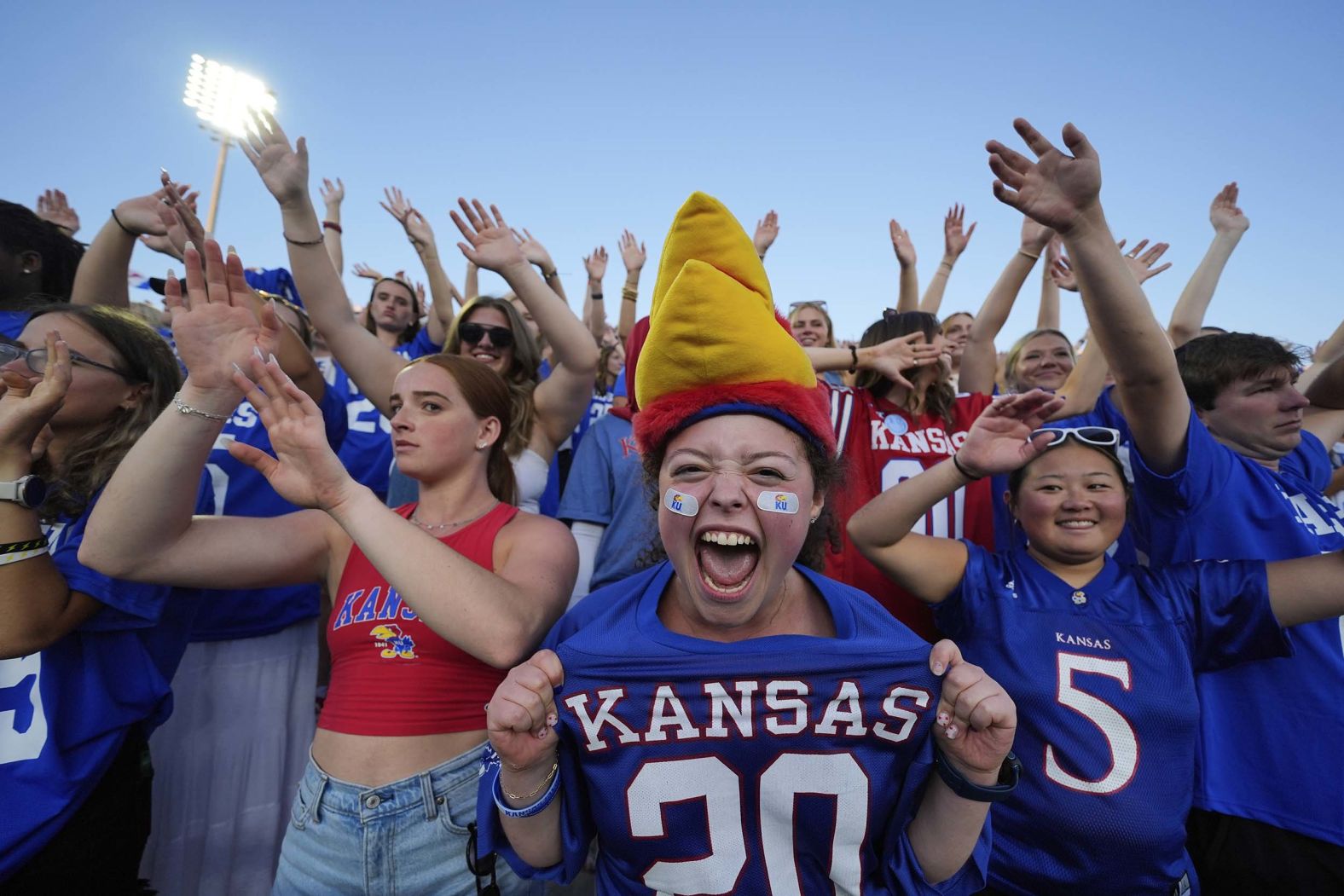 Fans cheer a Kansas touchdown during a college football game in Lawrence, Kansas, on Saturday, August 23.