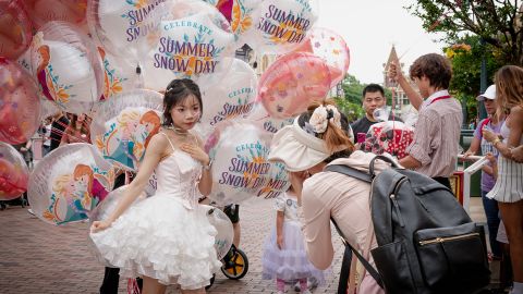 Deng Chundan, 16, and her friend take pictures inside Hong Kong Disneyland on June 7, 2024, in Hong Kong, China.