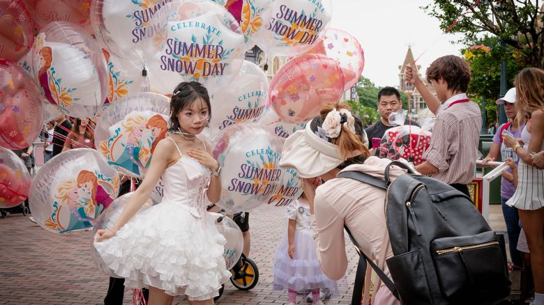 Deng Chundan, 16, and her friend take pictures inside Hong Kong Disneyland on June 7, 2024, in Hong Kong, China.