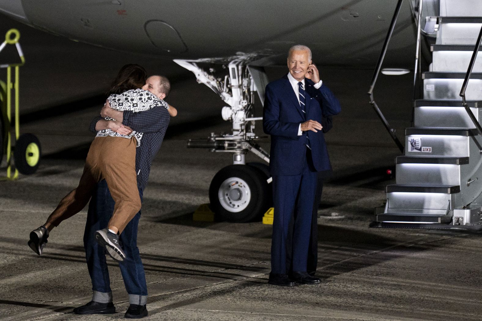 US President Joe Biden watches Wall Street Journal reporter Evan Gershkovich lift his mother, Ella Milman, after arriving at Joint Base Andrews in Maryland on Thursday, August 1. Gershkovich was among those freed as part of a <a href="index.php?page=&url=https%3A%2F%2Fwww.cnn.com%2F2024%2F08%2F01%2Fpolitics%2Frussia-us-prisoner-swap%2Findex.html">historic prisoner exchange with Russia</a>.