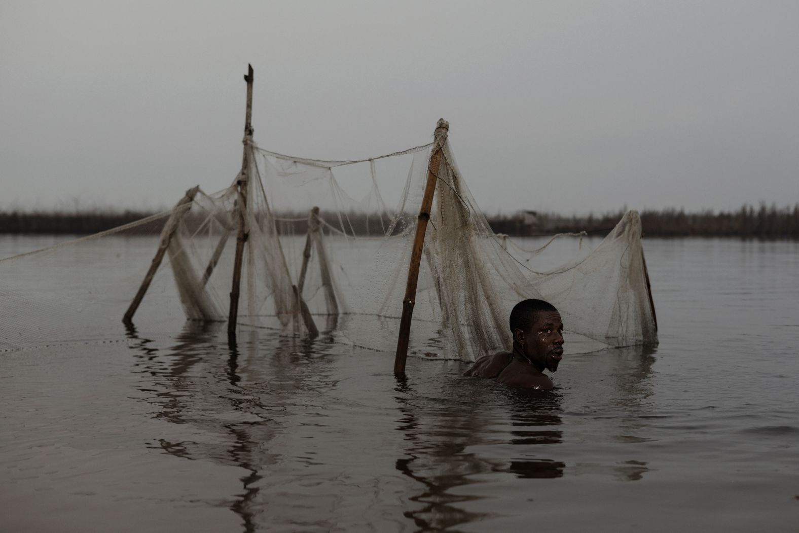 A fisherman tends to his net in the waters of Ganvie, Benin, on Wednesday, January 15.