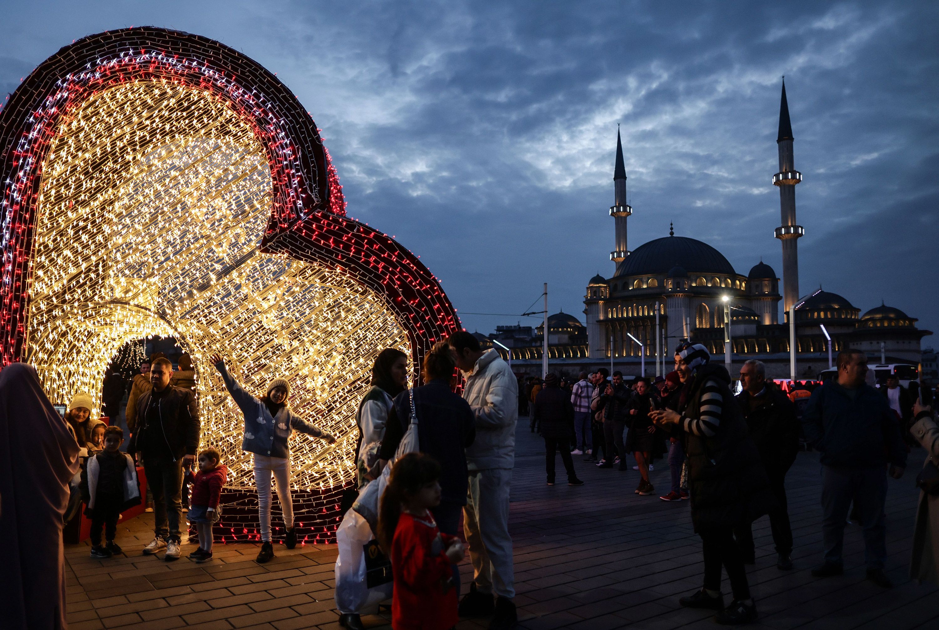 People take pictures with decorations in front of the Taksim Mosque in Istanbul, Turkey.