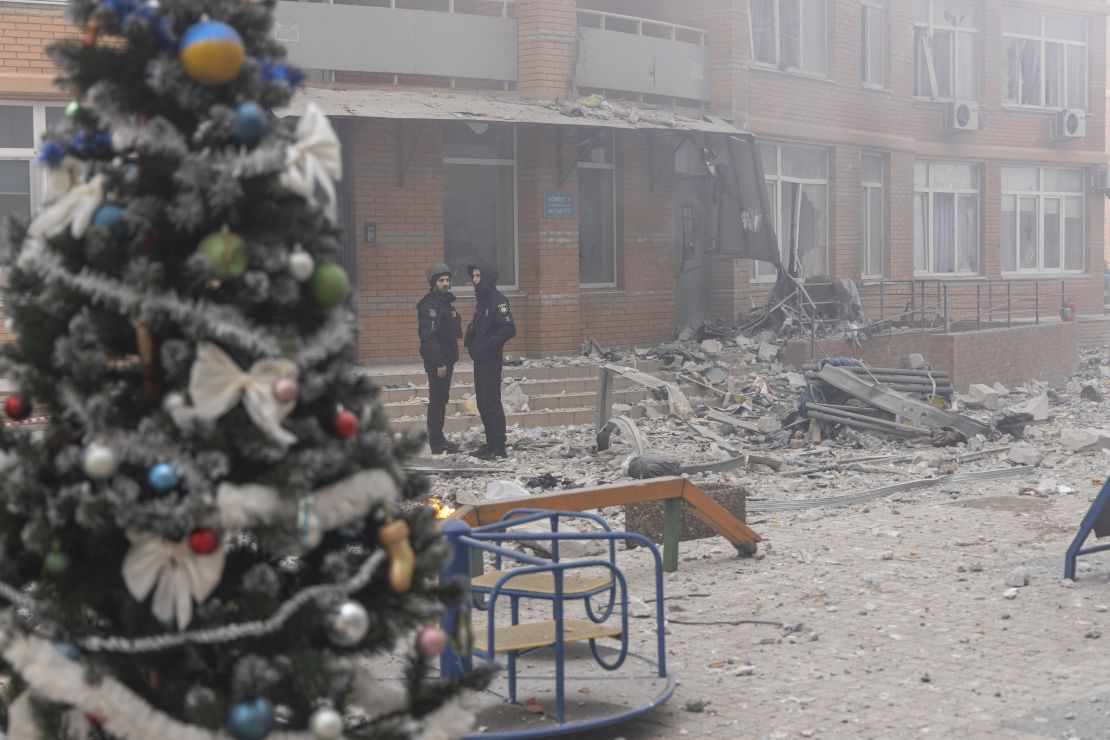 Policjanci stoją w pobliżu wieżowca trafionego rakietą po ataku rakietowym w Odessie podczas inwazji Rosji na Ukrainę, 29 grudnia 2023 r.  29 grudnia 2023 r. Rosja przeprowadziła ataki dronami i rakietami na całą Ukrainę, w największym nalocie tej wojny zginęło co najmniej 12 osób, a ponad 70 zostało rannych.  (Zdjęcie: Oleksandr Kimanov/AFP) (Zdjęcie: Oleksandr Kimanov/AFP za pośrednictwem Getty Images)