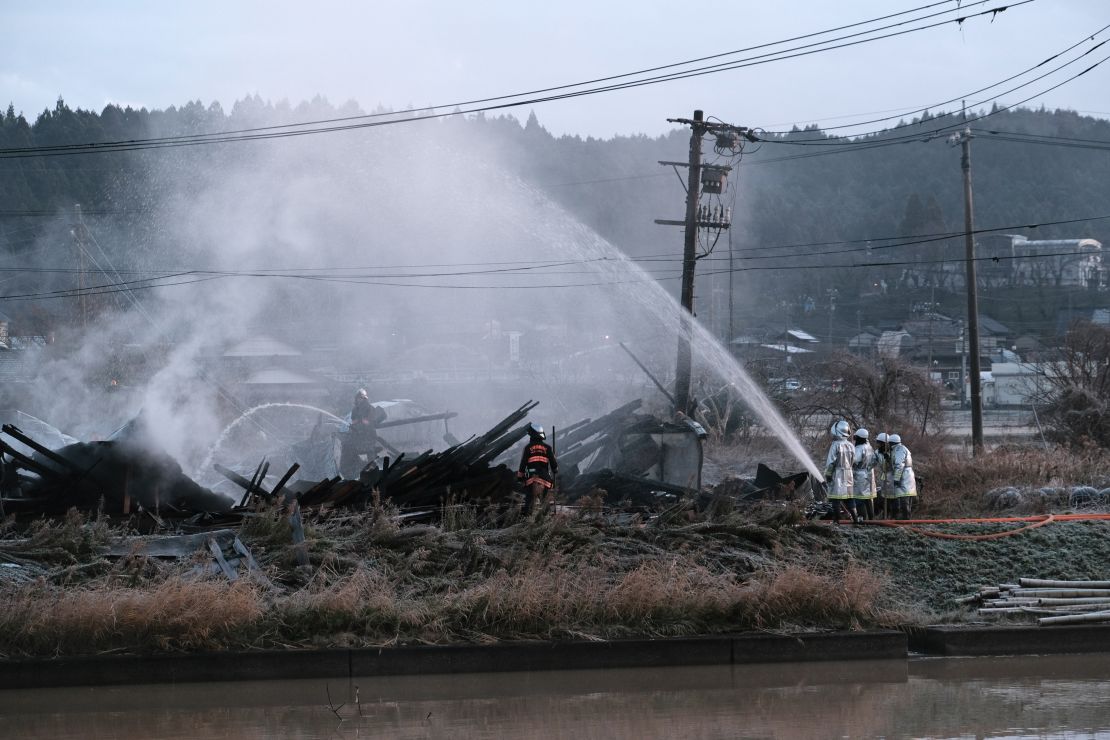 Firefighters extinguish a fire in Nanao, Ishikawa Prefecture, Japan, early on Tuesday, Jan. 2, 2024. At least six people were killed and others injured in a powerful earthquake that hit off the Noto Peninsula on Japan's northwest coast, wrecking buildings, buckling roads and triggering fires. Photographer: Soichiro Koriyama/Bloomberg via Getty Images
