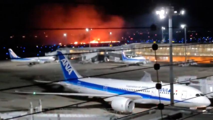 Fire is seen in this screengrab taken from video filmed at Tokyo Haneda airport on January 2. Japan Airlines says its flight 516 collided with what appears to be a Japan Coast Guard aircraft upon landing, according to NHK. All 367 passengers and 12 crew members on board the Japan Airlines plane that ignited upon landing have been evacuated, according to public broadcaster NHK.