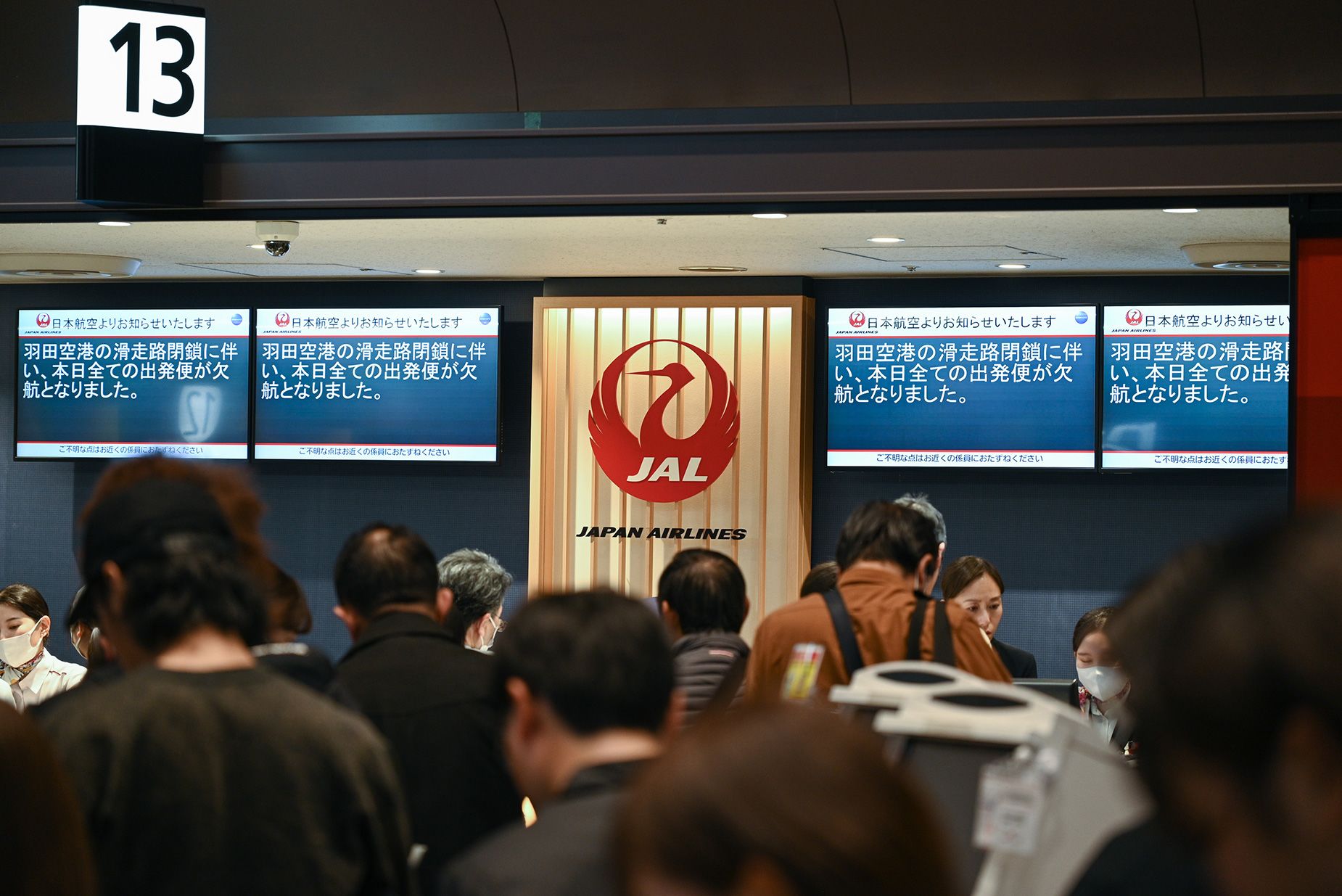 Des voyageurs font la queue au comptoir de service de Japan Airlines Co. à l'aéroport de Haneda à la suite d'annulations de vol en raison d'une collision d'avion à Tokyo, au Japon, le mardi 2 janvier 2024. Des images de l'aérodrome à l'extérieur du bâtiment de l'aéroport de Haneda semblent montrer l'Airbus. est entré en collision avec l'autre avion juste après son atterrissage à la tombée de la nuit, puis a dérapé dans une traînée de flammes. Photographe : Kentaro Takahashi/Bloomberg via Getty Images
