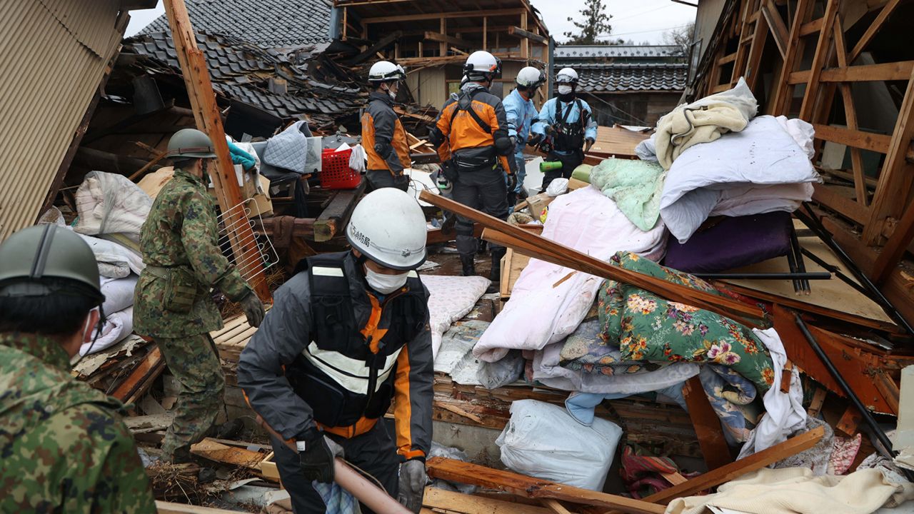 Fire fighters and Self-Defense Force members rescue an elderly man in cardiopulmonary arrest from a collapsed house on January 3, 2024 in Suzu, Ishikawa, Japan.