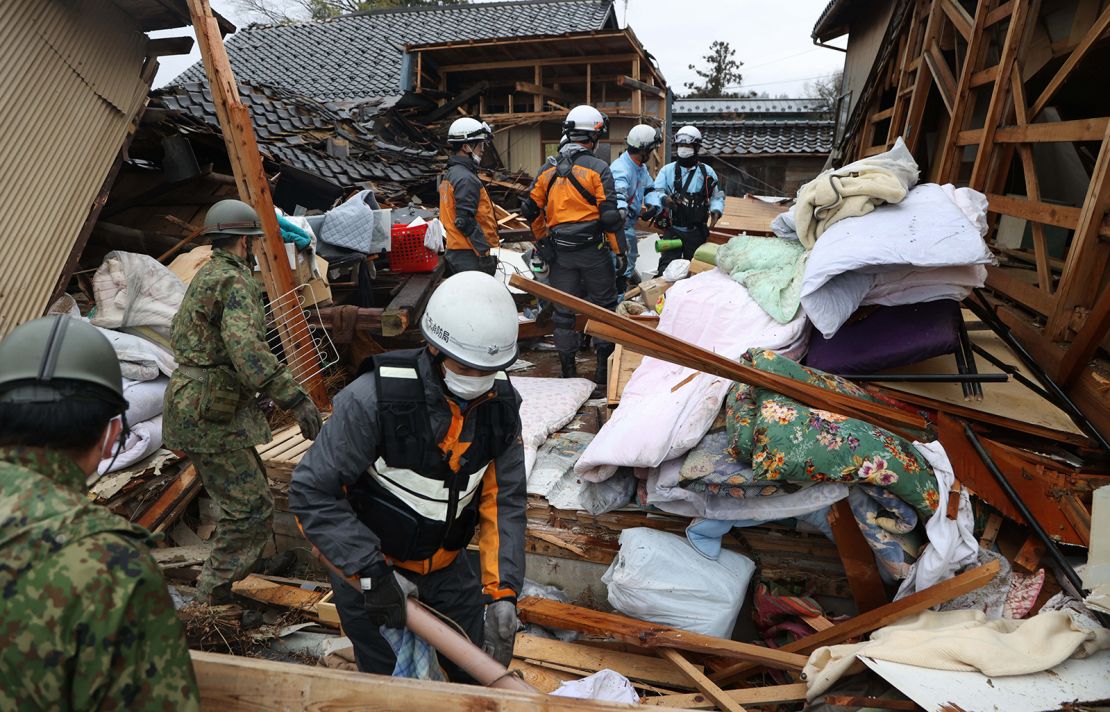 Fire fighters and Self-Defense Force members rescue an elderly man in cardiopulmonary arrest from a collapsed house on January 3, 2024 in Suzu, Ishikawa, Japan.