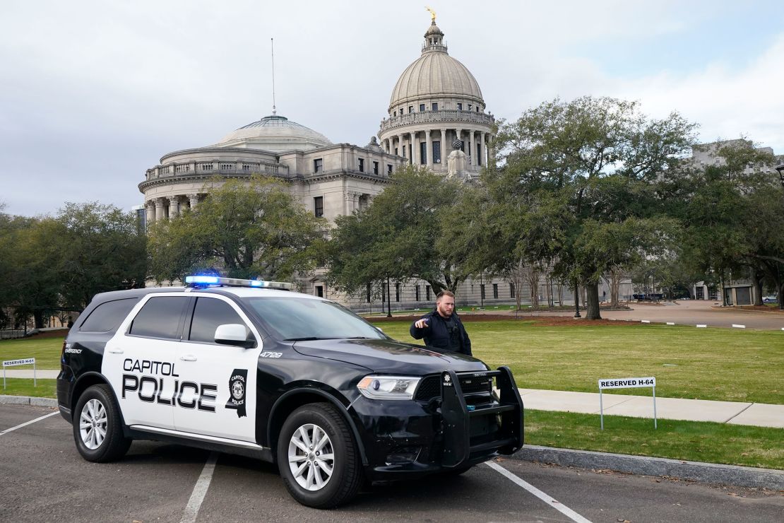 A Capitol Police officer warns off passersby as they respond to a bomb threat at the Mississippi State Capitol in Jackson, Miss., Wednesday morning, Jan. 3, 2024. The building was emptied, the grounds cleared of vehicles as officers investigated. (AP Photo/Rogelio V. Solis)