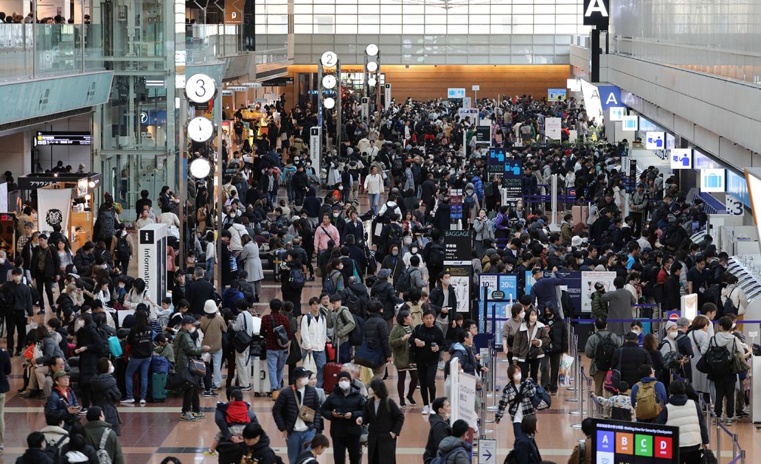 Travelers crowd the check-in area at terminal 2 at Tokyo International Airport at Haneda on January 3, 2024, as flight delays on one of the busiest travel days of the year following the New Year's Day holidays were made worse due to the collision on the tarmac the night before between a coast guard plane and a Japan Airlines (JAL) passenger jet, shutting down one of the main runways.
