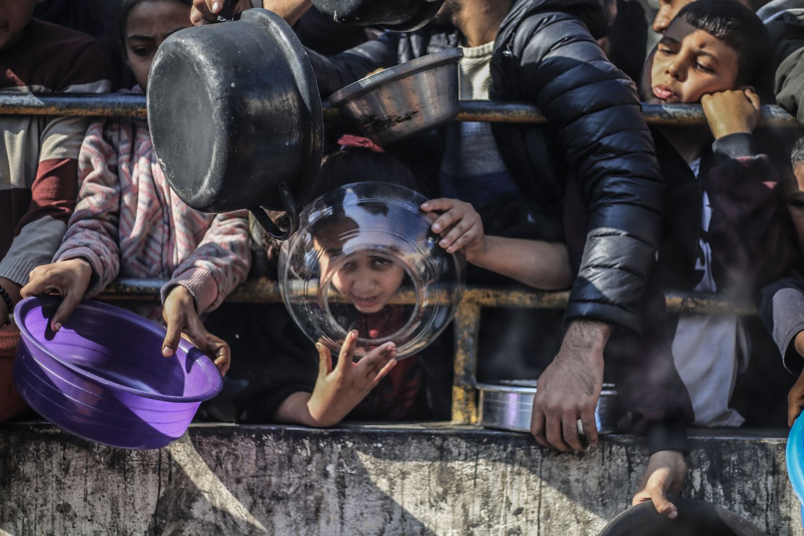 Palestinian children wait to receive food at a charity kitchen in Rafah, Gaza, on Sunday, December 31. Gaza's population has been gripped by humanitarian crisis after Israel, fighting Hamas militants in Gaza, cut off access to food, water and electricity.