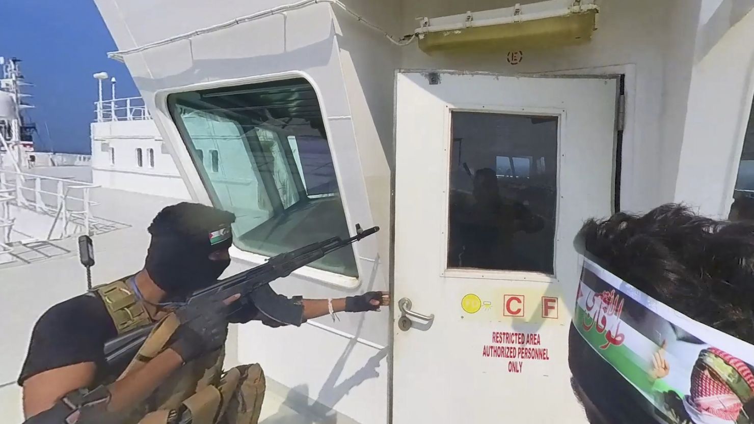 This photo released by the Houthi Media Center shows Houthi forces boarding the cargo ship Galaxy Leader on Sunday, Nov. 19, 2023. Yemen's Houthis have seized the ship in the Red Sea off the coast of Yemen after threatening to seize all vessels owned by Israeli companies. (Houthi Media Center via AP)