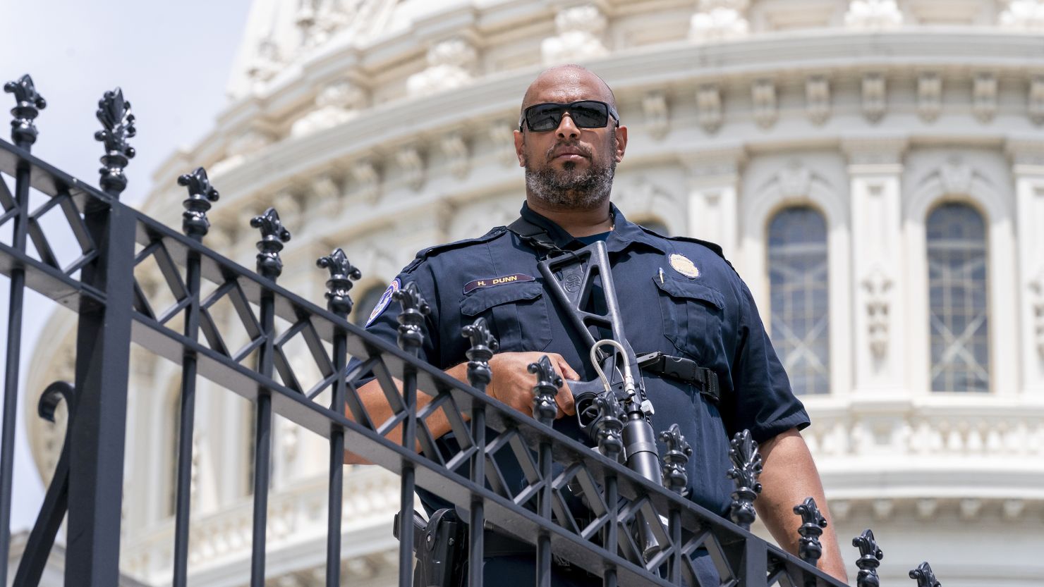 U.S. Capitol Police Sgt. Harry Dunn, who defended the Capitol when pro-Trump insurrectionists attacked Jan. 6, 2021, keeps watch over the East Plaza while Speaker of the House Nancy Pelosi, D-Calif., and other lawmakers hold an event on the House steps, at the Capitol in Washington, Friday, June 24, 2022. (AP Photo/J. Scott Applewhite)
