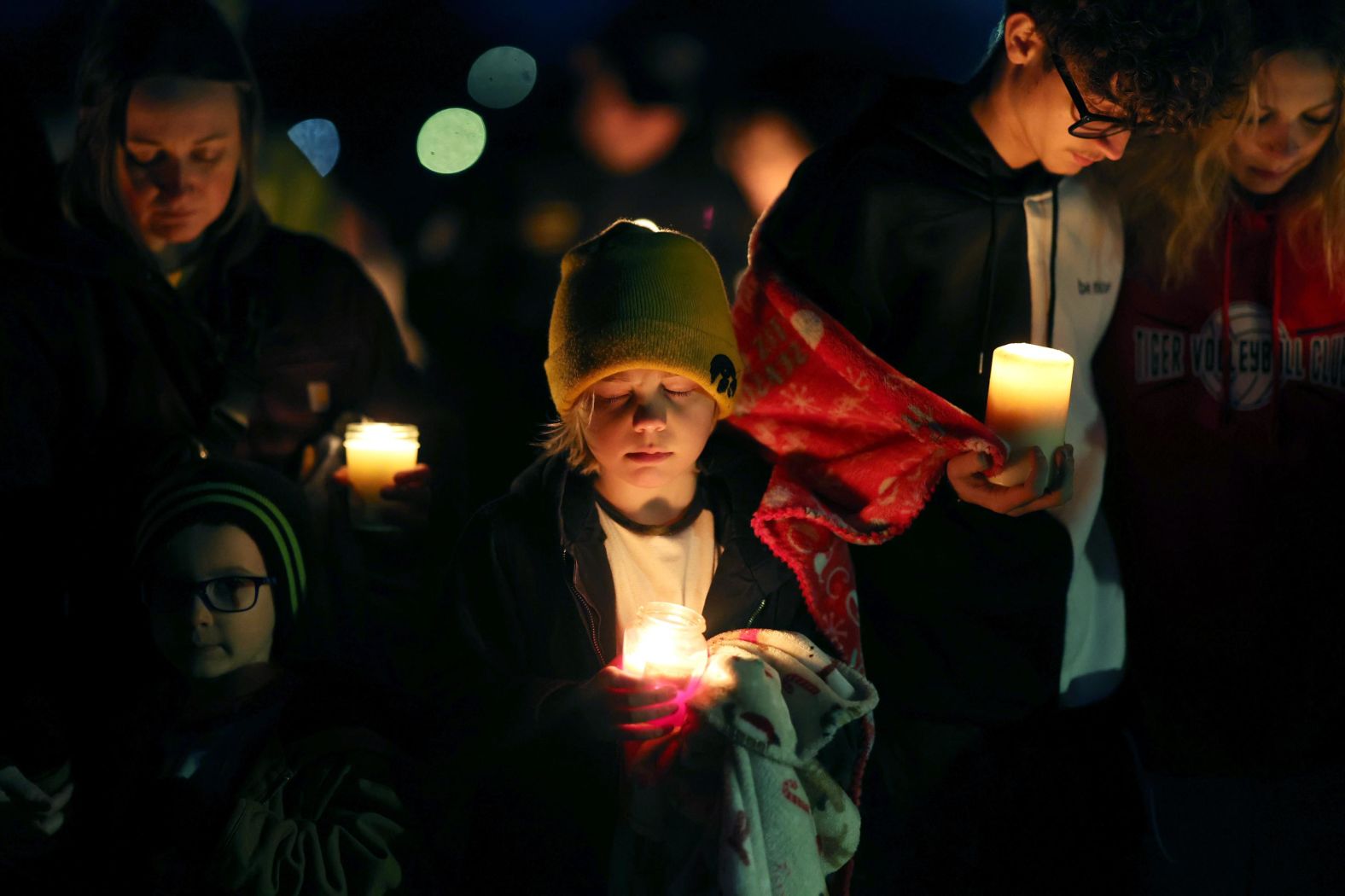 Residents pray during a candlelight vigil following <a href="index.php?page=&url=https%3A%2F%2Fwww.cnn.com%2F2024%2F01%2F04%2Fus%2Fiowa-shooting-perry-high-school%2Findex.html" target="_blank">a shooting at Perry High School</a> in Perry, Iowa, on Thursday, January 4. A gunman killed a sixth-grade student and wounded five other people at the school, according to Mitch Mortvedt of the Iowa Division of Criminal Investigation. Mortvedt identified the gunman as 17-year-old Dylan Butler, who was found by police with a self-inflicted gunshot wound.