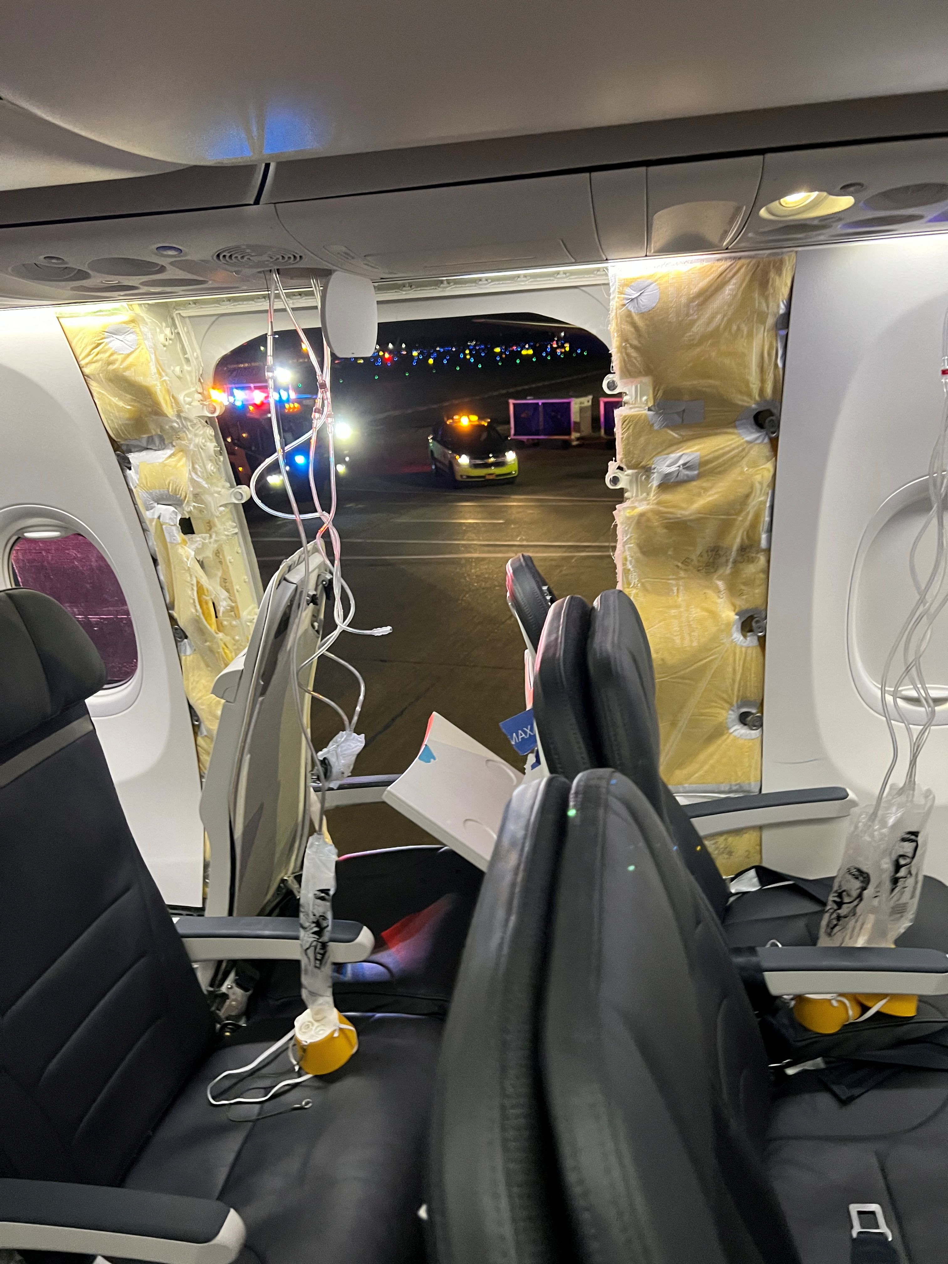 Passenger oxygen masks hang from the roof next to a missing window and a portion of a side wall of an Alaska Airlines Flight 1282, which had been bound for Ontario, California and suffered depressurization soon after departing, in Portland, Oregon, U.S., January 5, 2024 in this picture obtained from social media.