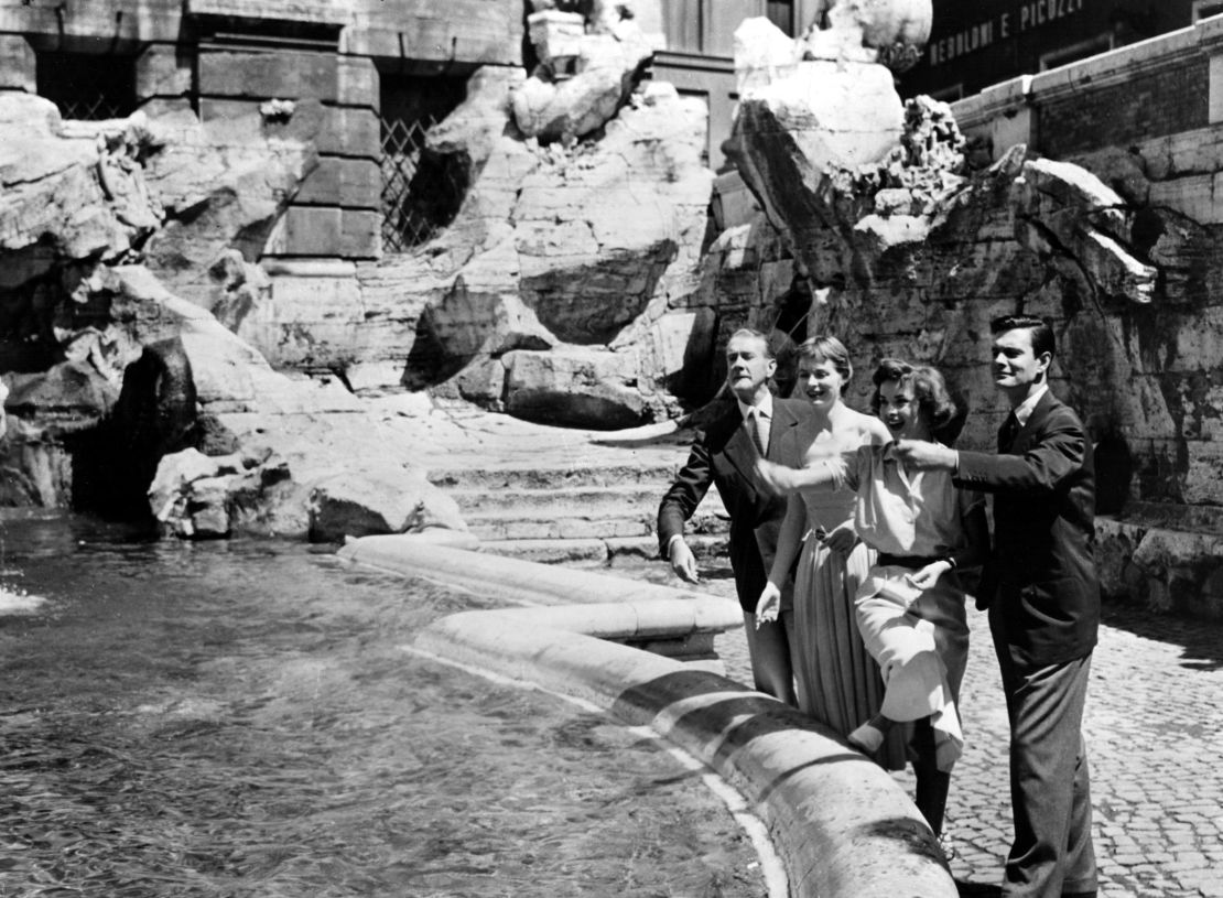 THREE COINS IN THE FOUNTAIN cast members CLIFTON WEBB, DOROTHY McGUIRE, JEAN PETERS and LOUIS JOURDAN throw their loose change in Rome's famed Trevvi fountain while on-location for the movie, 1954.